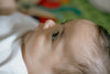 close up of a babys face in profile on colorful mat