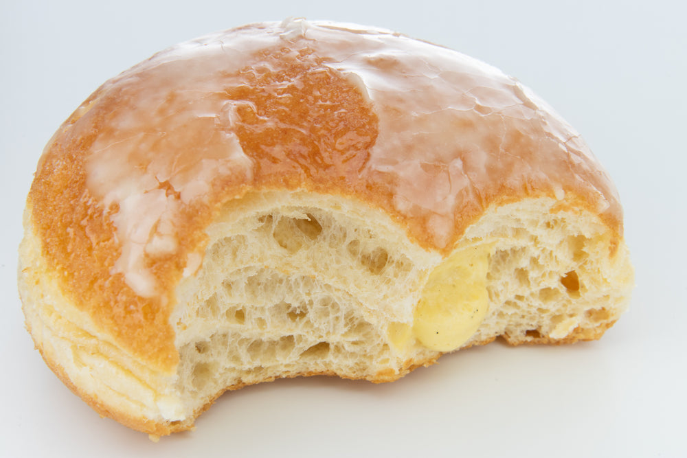 close up of a bitten glazed doughnut