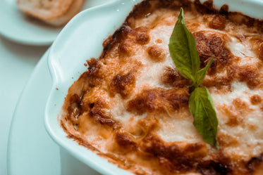 close up of a cooked browned dish with a basil garnish