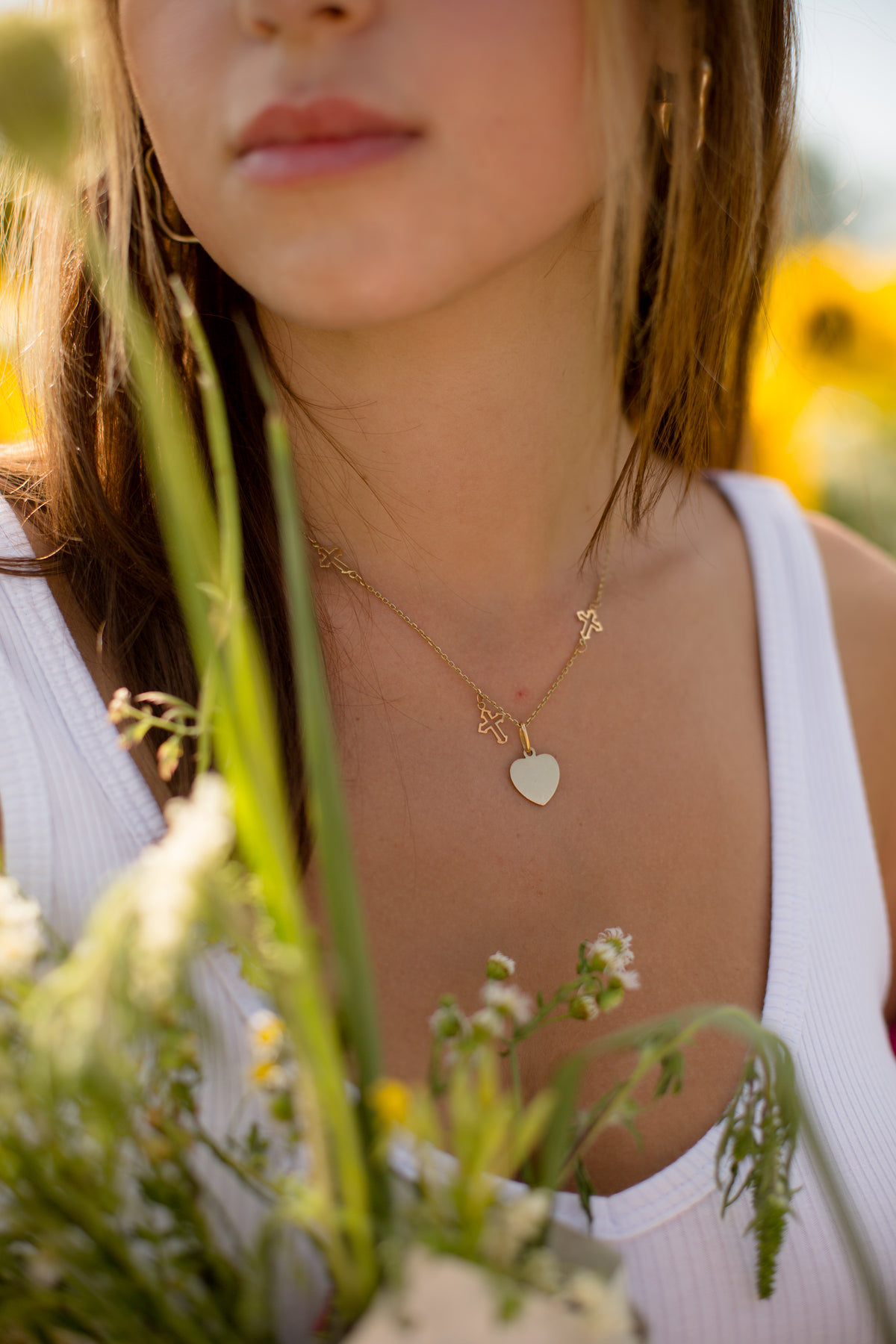 close up of a gold necklace on a person in a white shirt