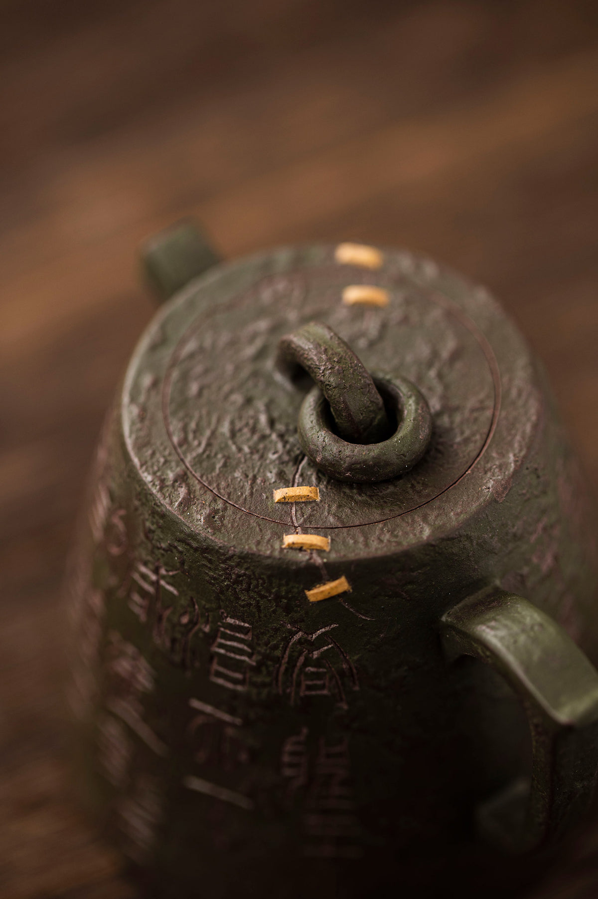 close up of a metal teapot with gold lines