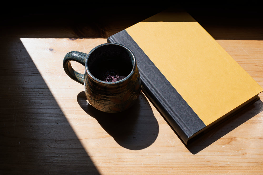 close up of a mug and a book in light