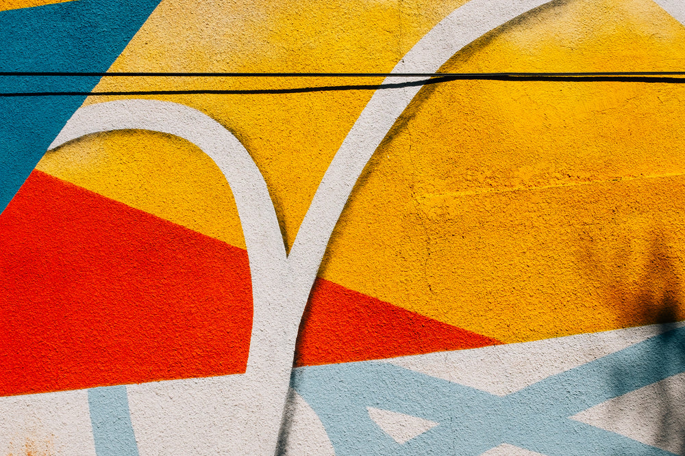 close up of a painted cement wall with splashes of colour