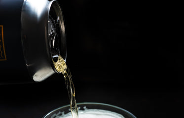 close up of a silver can pouring golden liquid