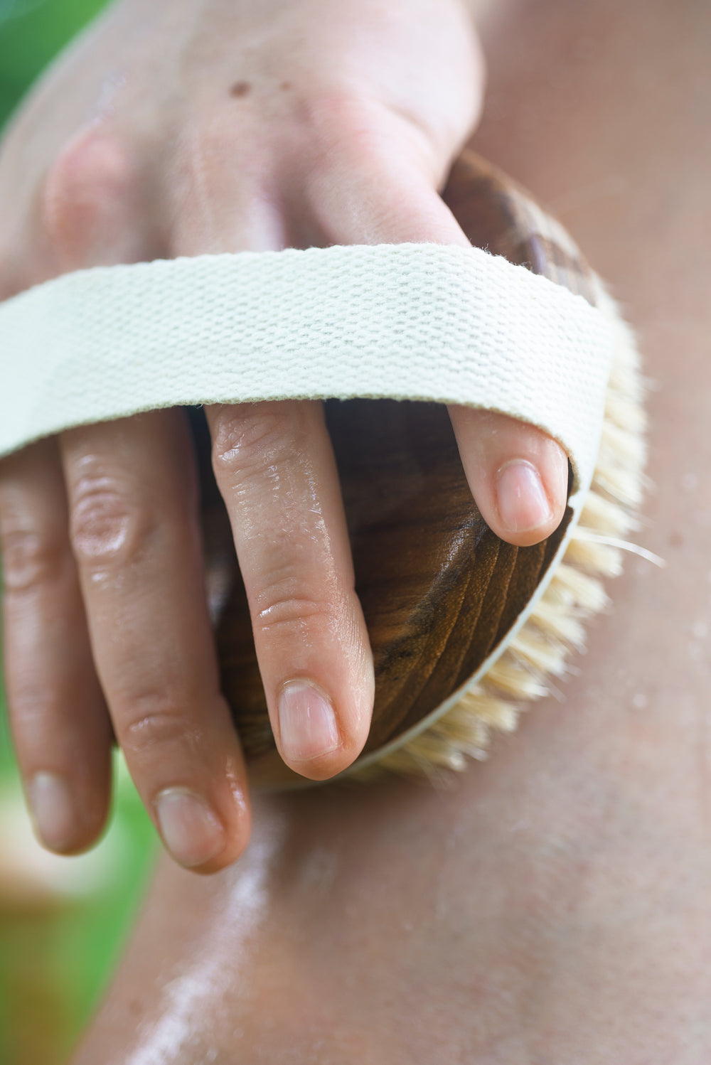 close up of a wooden scrub brush exfoliating