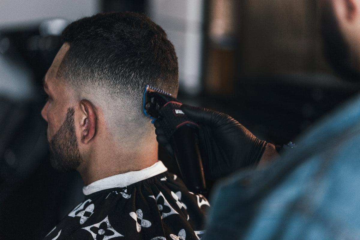 Close-up of a barber using clippers to create a fade