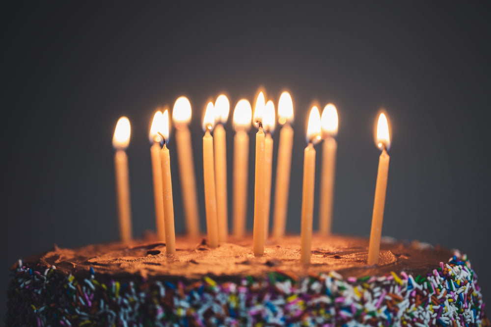 close up of candles lit on chocolate cake
