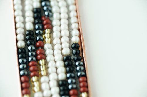 close up of different colored beads on white background