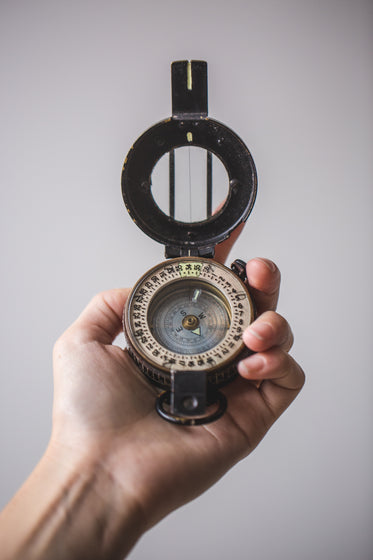 close up of hand holding compass