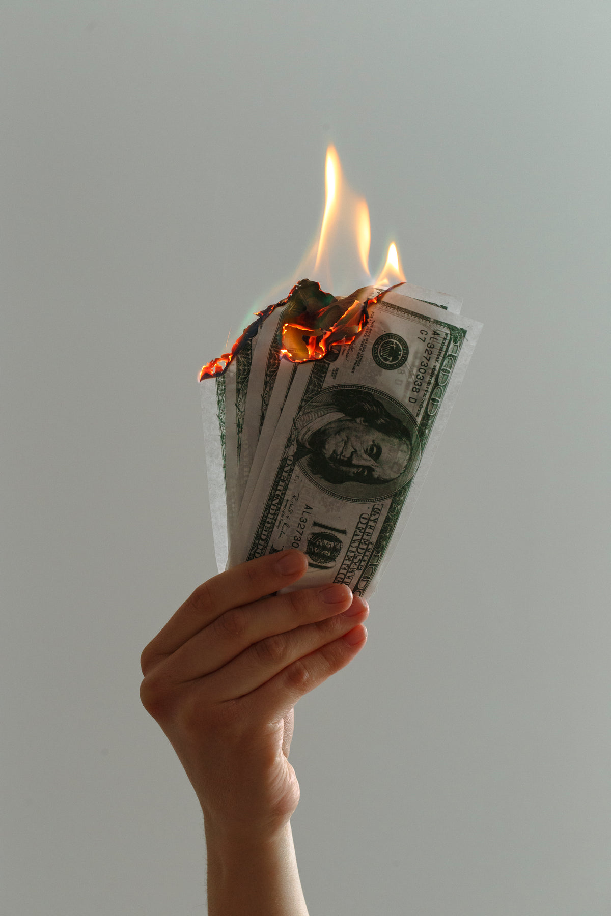 close up of hand holding up burning notes