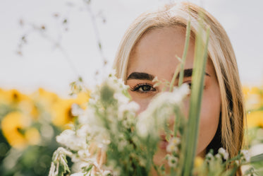 close up of person with brown eyes looking through foliage