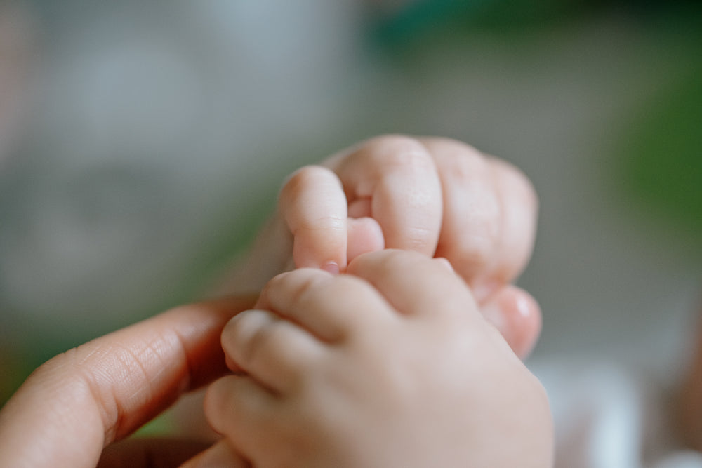 close up of soft pink hands of young baby
