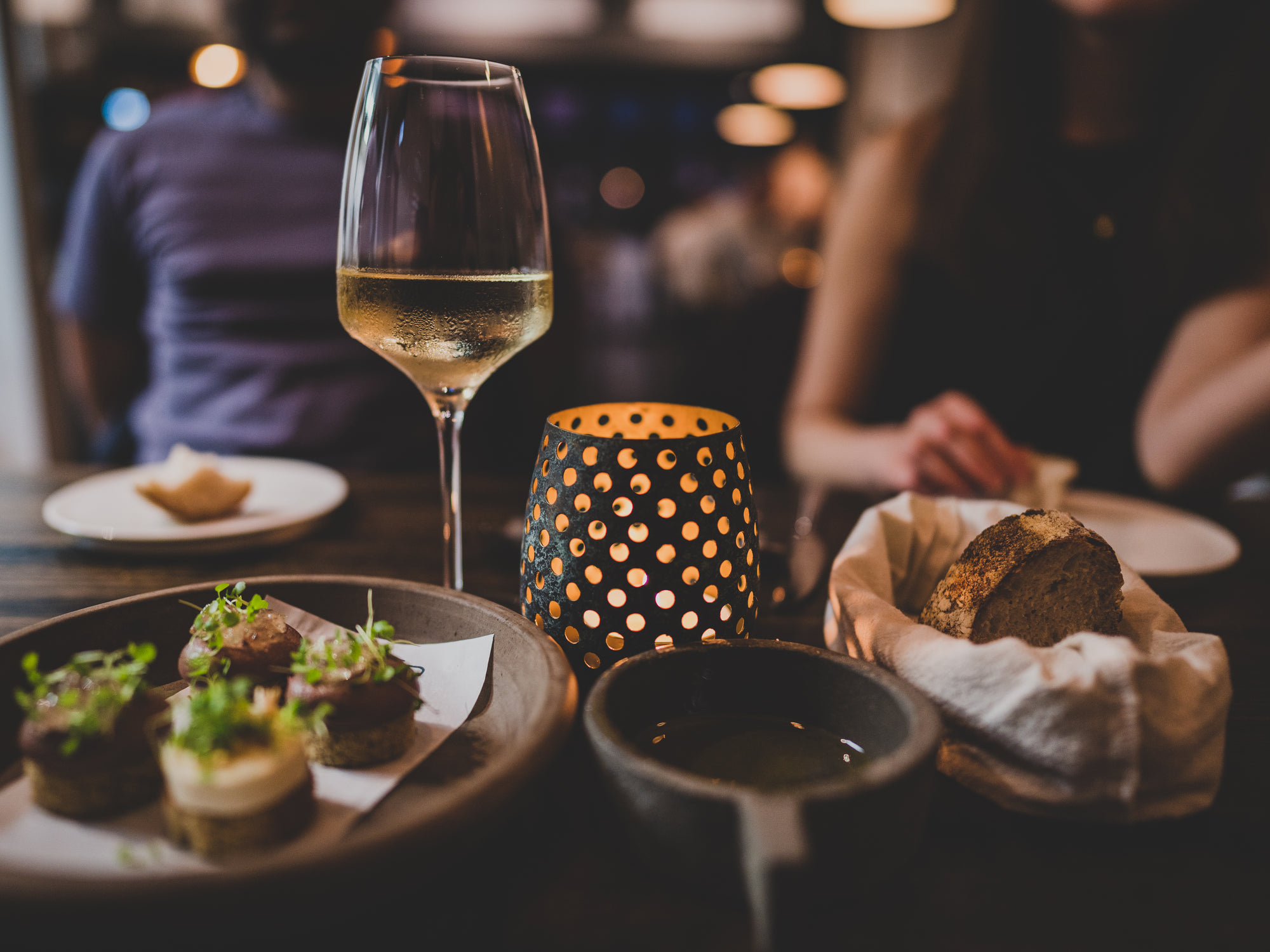 A dinner table set with wine glasses and water tumblers