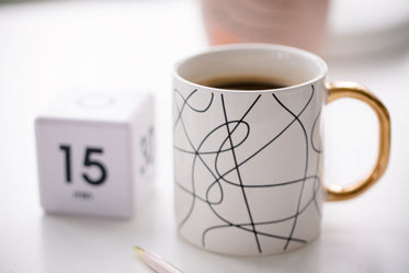 close up white mug filled with coffee on a desk