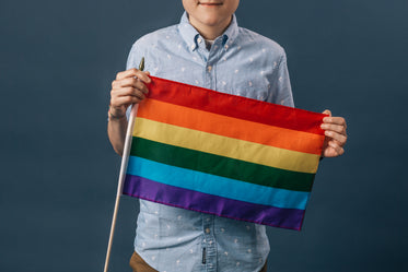 closer up person holding a small pride flag