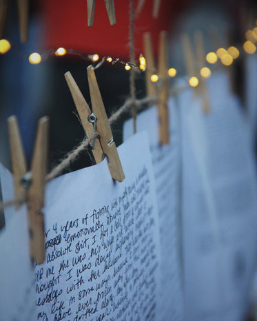 clothes pins holds up white paper with writing
