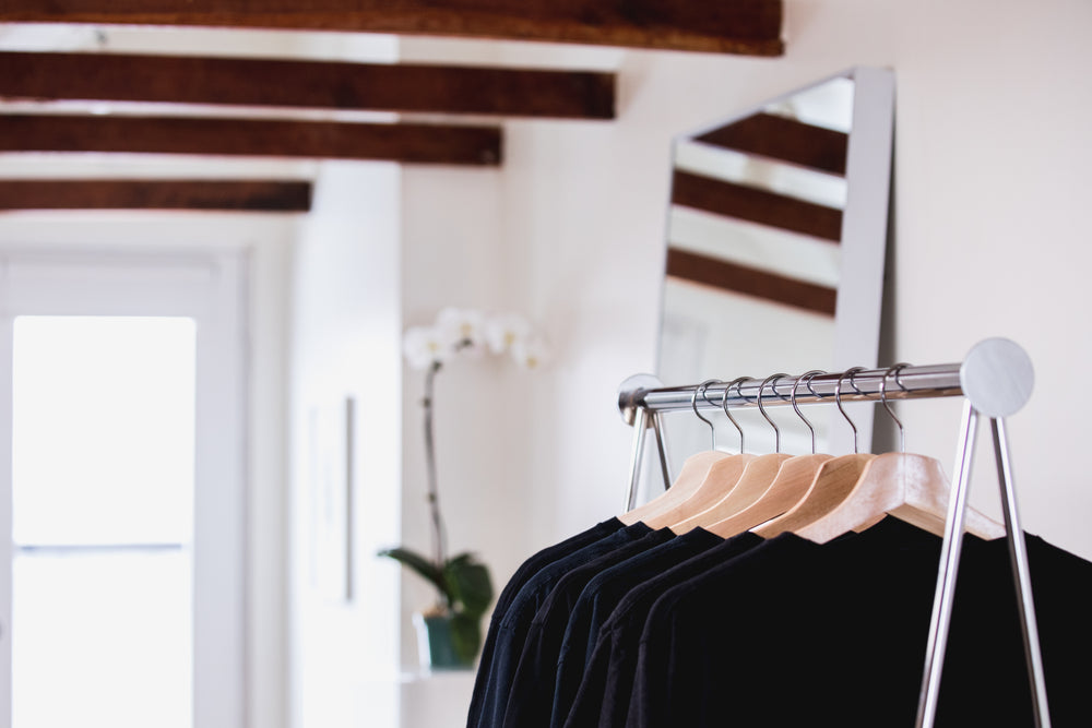 clothing on a shop rack with flowers in the background