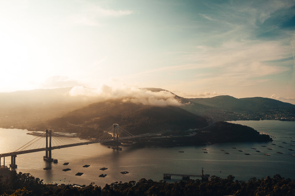 clouds drift over bridge on water