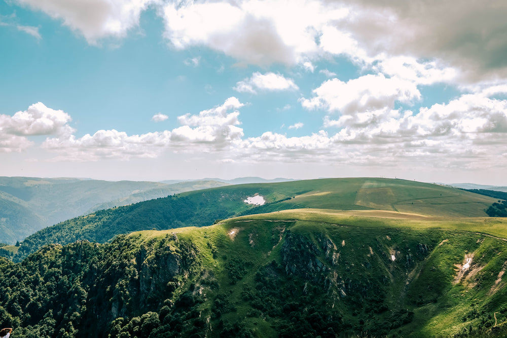 clouds scatter shadows of sprawling green ridges and hills