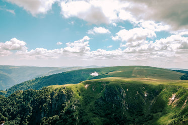 clouds scatter shadows of sprawling green ridges and hills