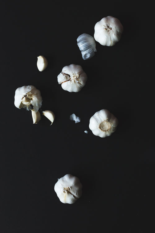 cloves of garlic on a black background