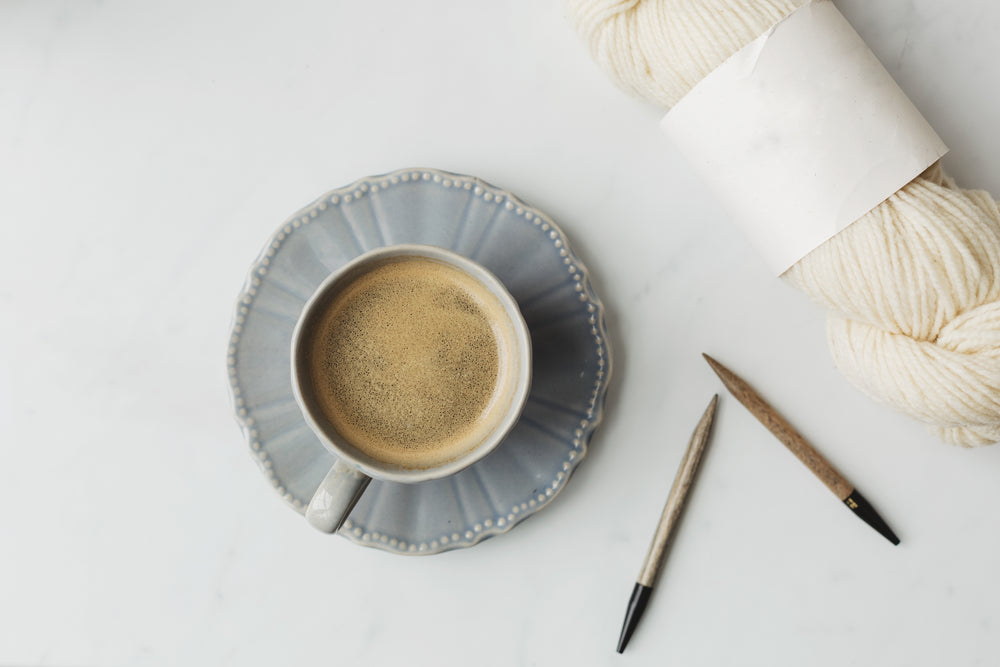 coffee in a tea cup and wool for knitting