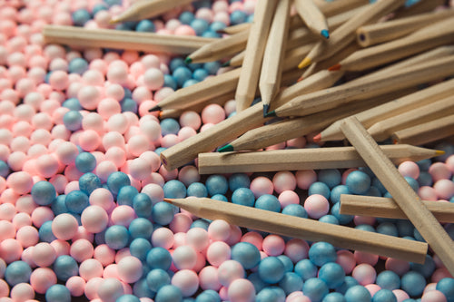 colored pencils scattered on pink and blue balls