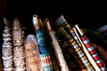 colored ribbon around sheets of cardboard on bookshelves