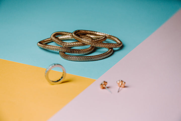 Gold jewellery on a colourful set