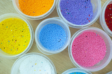 colorful beads arranged in pots on a table