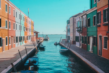 colorful buildings and boats lead to calm blue water
