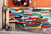 colorful geometric wall art on a shabby street