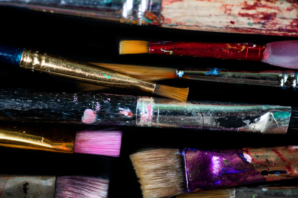 colorful paint brushes in front of black background
