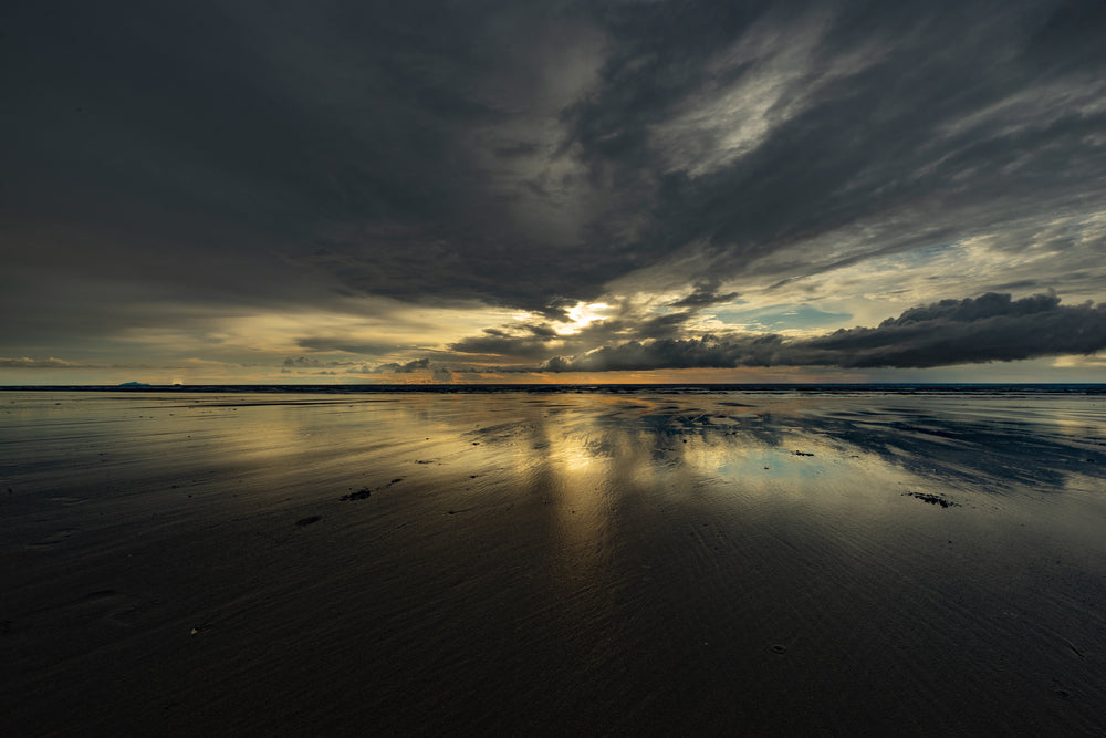 colorful sunset reflected in wet sand