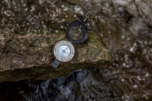compass resting by a creek