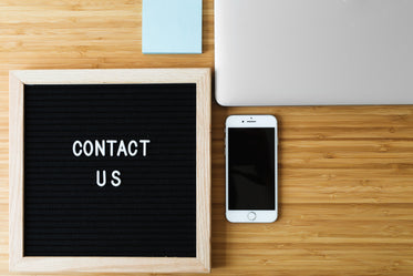 contact us sign with phone on desk