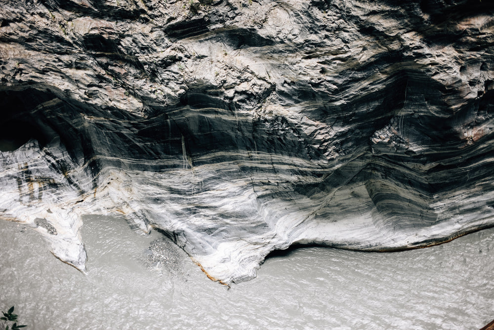 contoured monochrome rock face above river