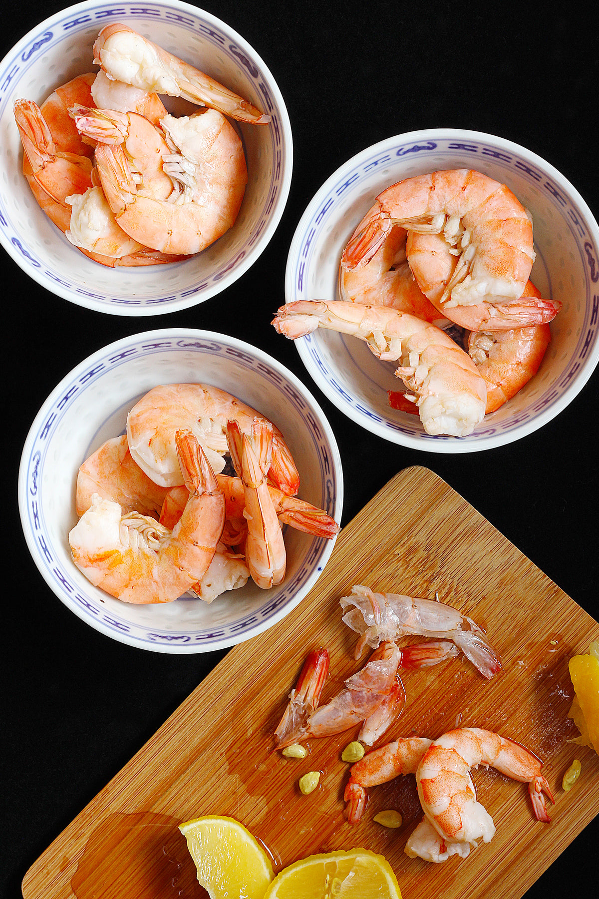cooked shrimp dressed with lemon juice in china bowls