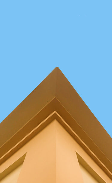 corner of a yellow buildings against. a blue sky