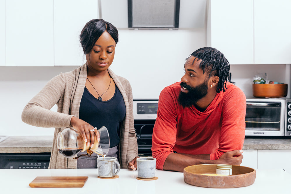 couple chat and make coffee in their kitchen