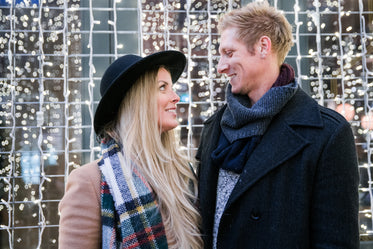 couple gazing in front of holiday lights