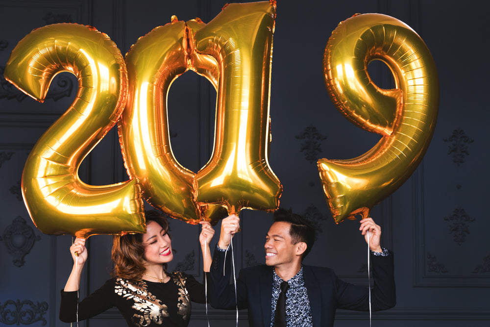 couple holding 2019 helium balloons