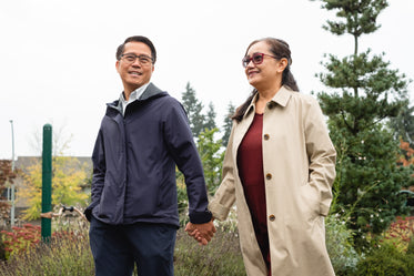 couple holds hands and walks though a empty park