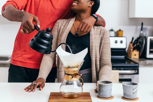 couple hug as they pour a cup of coffee