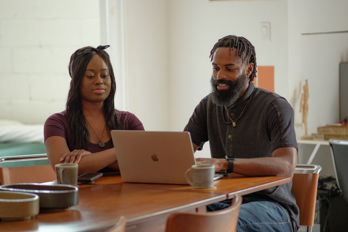 Small business owners reviewing an online store and website plans on a laptop at a dining table
