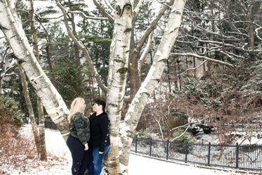 couple shares a loving look near a tall tree