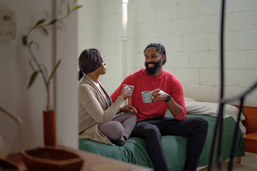 couple sip coffee on the bed