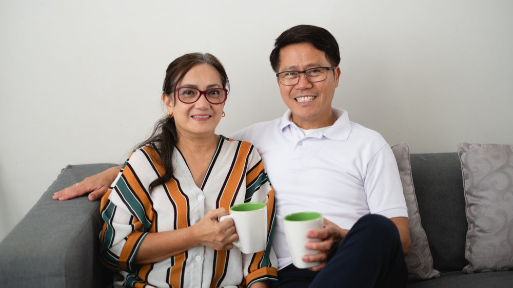 couple sitting on couch with coffees