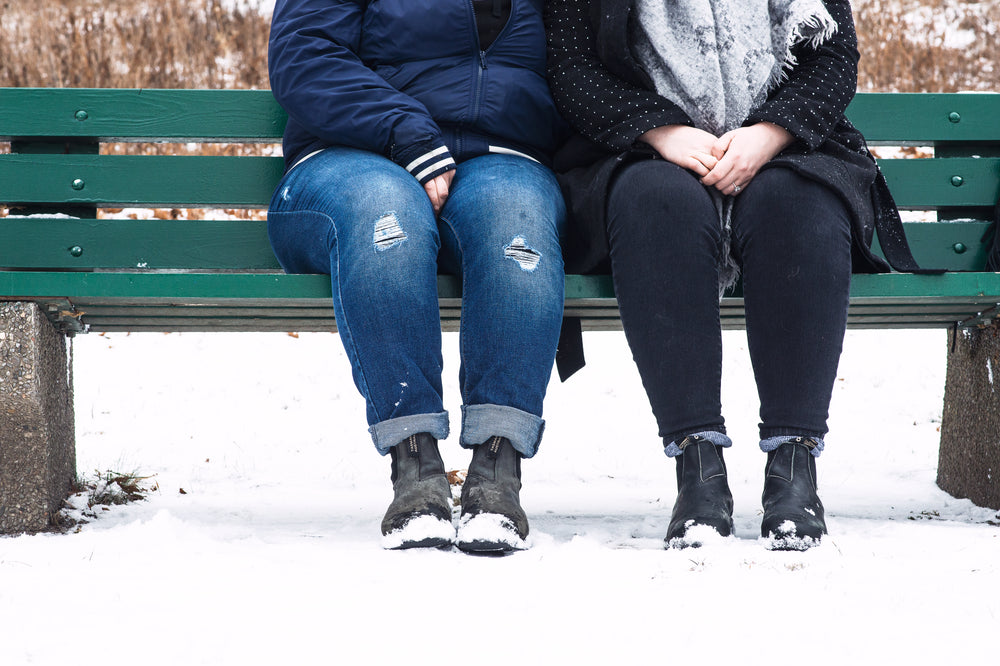 couple sitting side by side with hands in the laps