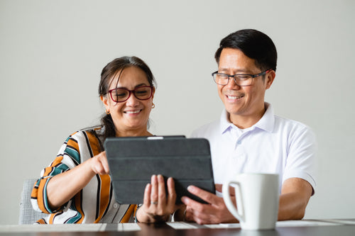 couple smile as the use a tablet